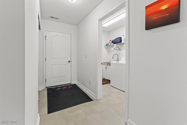 doorway to outside featuring washer / dryer, light floors, visible vents, and baseboards