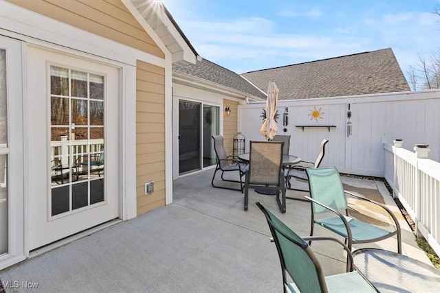 view of patio featuring outdoor dining area and fence