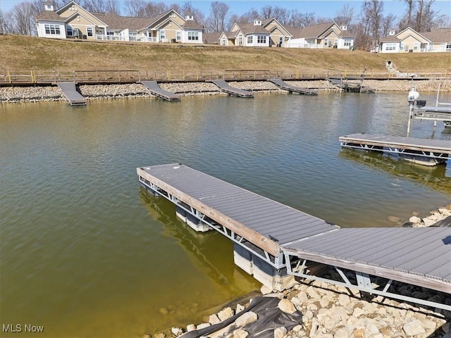 view of dock with a residential view and a water view