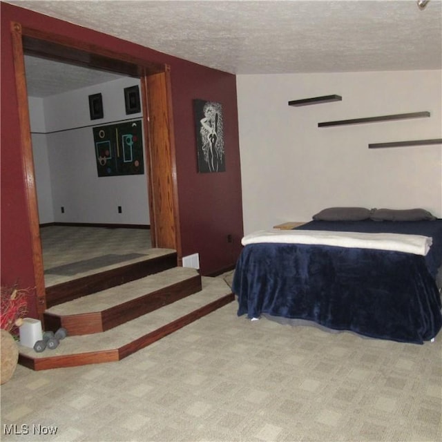 bedroom with visible vents, carpet floors, and a textured ceiling