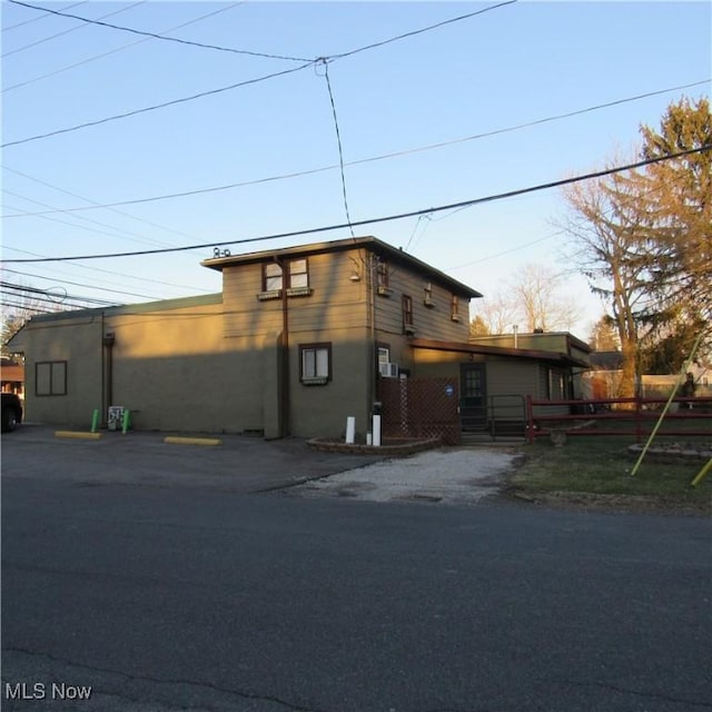 view of front facade with stucco siding and uncovered parking