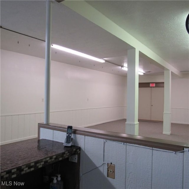 finished basement with a wainscoted wall