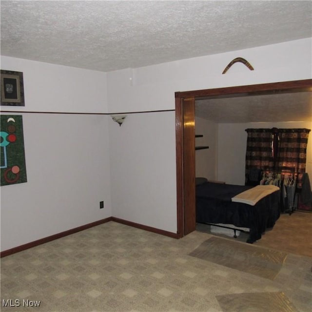 unfurnished bedroom with baseboards and a textured ceiling