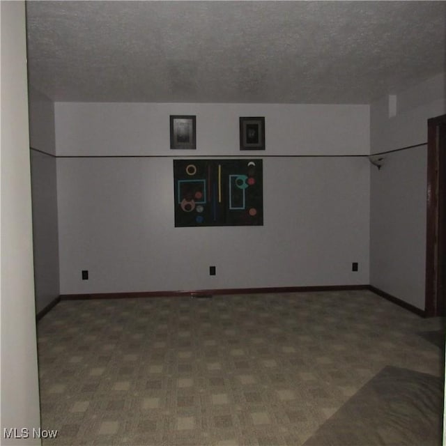 spare room featuring baseboards and a textured ceiling