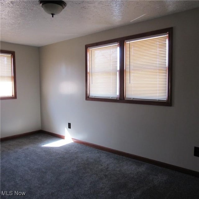 unfurnished room with baseboards, a textured ceiling, and carpet flooring