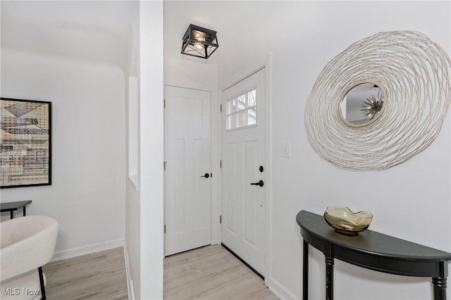 entryway featuring baseboards and light wood-type flooring