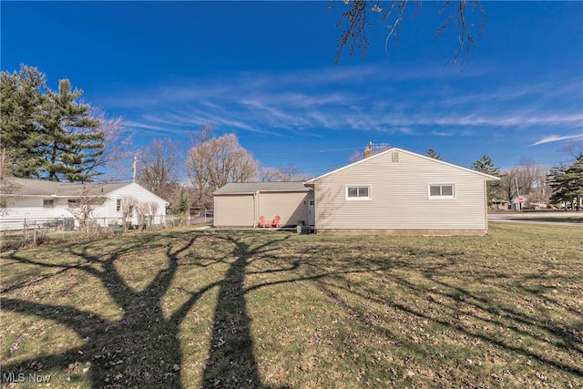 view of side of home featuring a yard and fence