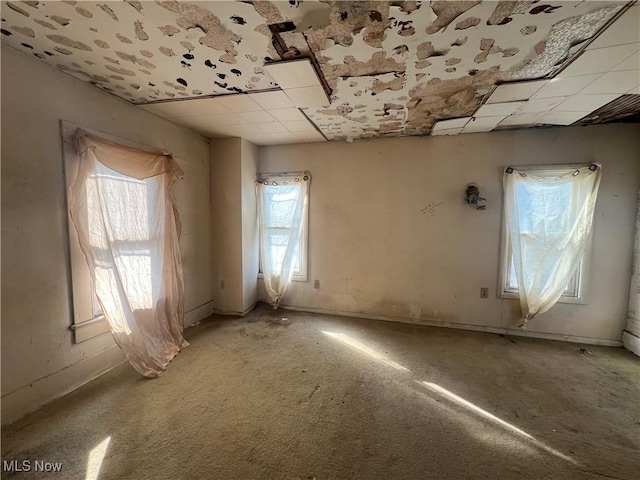 unfurnished room featuring light carpet and a paneled ceiling