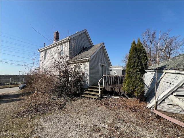 view of side of property with a deck and a chimney