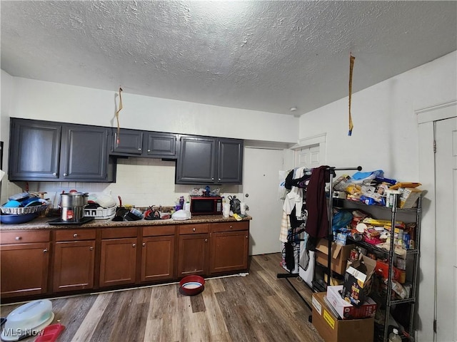 kitchen with dark wood-style floors, black microwave, and a textured ceiling