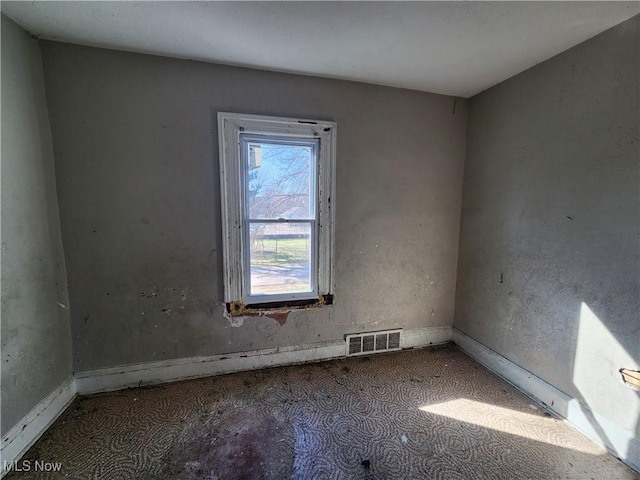 unfurnished room with visible vents