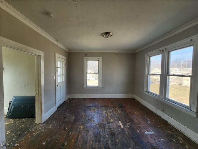 unfurnished dining area with hardwood / wood-style floors, baseboards, a textured ceiling, and ornamental molding