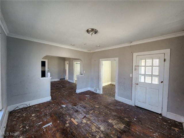 interior space with baseboards, arched walkways, ornamental molding, and hardwood / wood-style flooring