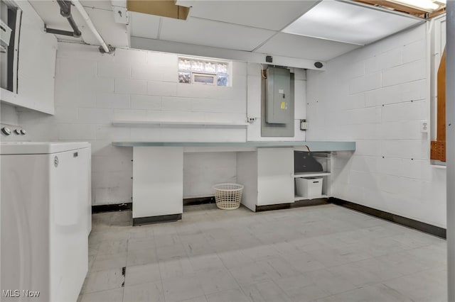 interior space featuring electric panel, light floors, washer / dryer, and concrete block wall