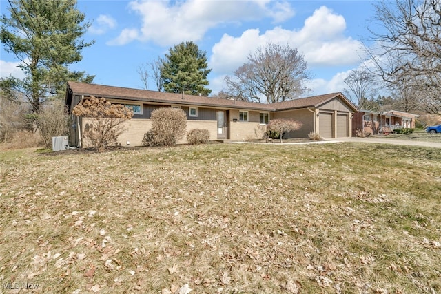 ranch-style home with a garage, driveway, brick siding, and a front yard