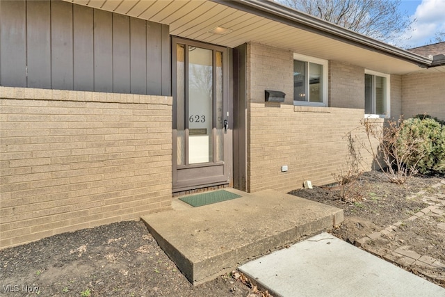 view of exterior entry with brick siding