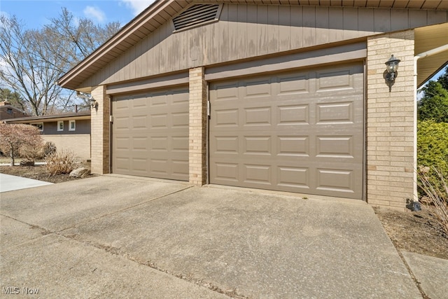 garage featuring concrete driveway