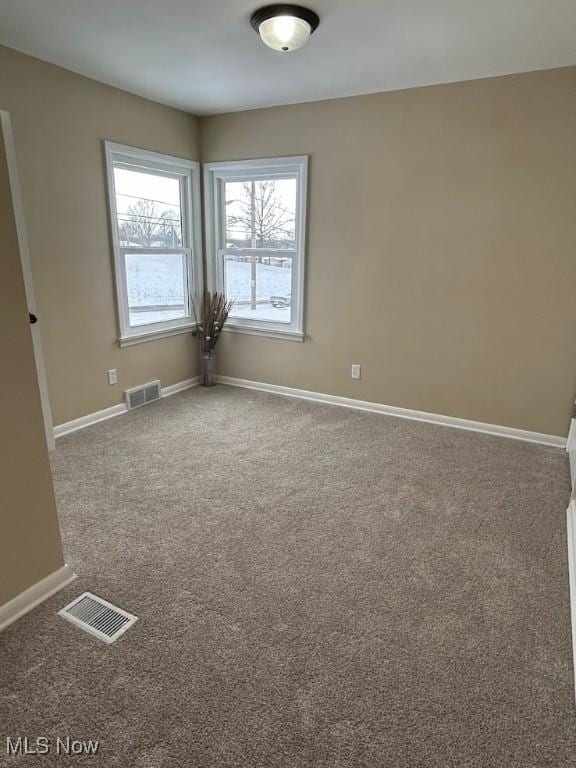 unfurnished room featuring visible vents, baseboards, and carpet