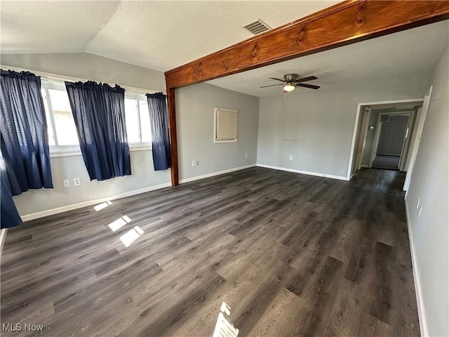 empty room featuring visible vents, dark wood-style floors, baseboards, ceiling fan, and vaulted ceiling with beams