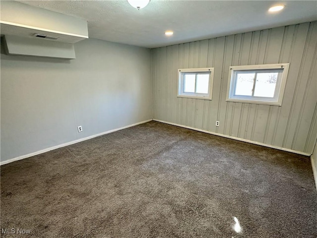 carpeted empty room with visible vents and baseboards