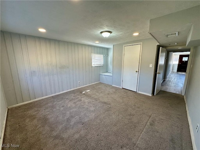 unfurnished bedroom with visible vents, carpet flooring, a textured ceiling, and multiple windows