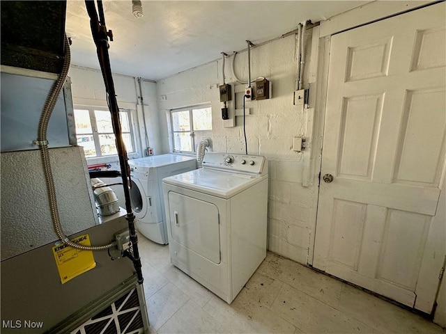 laundry area with concrete block wall, laundry area, and washer and clothes dryer