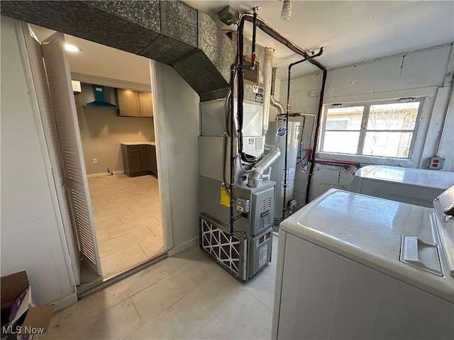 laundry room with baseboards, gas water heater, washing machine and dryer, laundry area, and heating unit