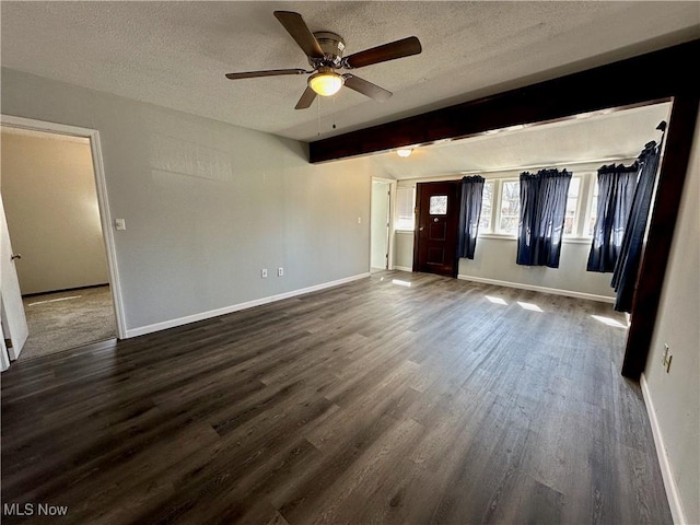 spare room with dark wood finished floors, ceiling fan, baseboards, and a textured ceiling