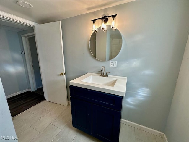 bathroom featuring vanity, baseboards, and wood tiled floor