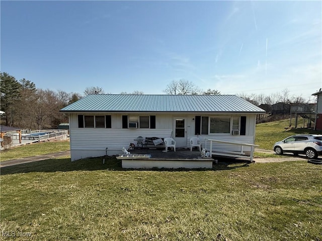 back of property featuring a lawn and metal roof