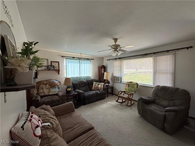 carpeted living area featuring cooling unit, a textured ceiling, and a ceiling fan