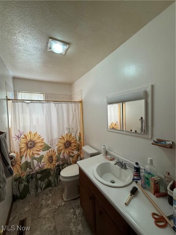 full bathroom featuring visible vents, toilet, vanity, a shower with curtain, and a textured ceiling