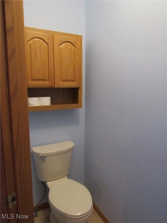 bathroom with baseboards and toilet