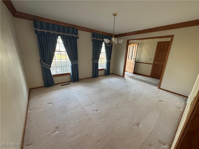 carpeted spare room with a chandelier, visible vents, crown molding, and baseboards