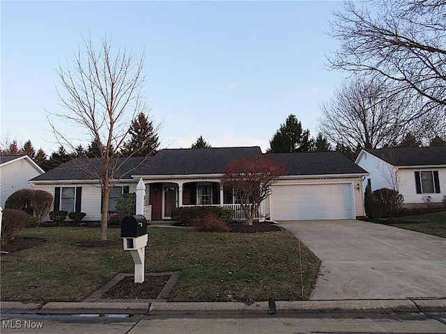 ranch-style home featuring a porch, driveway, an attached garage, and a front yard