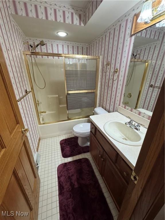 bathroom with vanity, enclosed tub / shower combo, wallpapered walls, tile patterned floors, and toilet