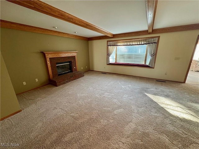 unfurnished living room with visible vents, a brick fireplace, baseboards, carpet, and beam ceiling