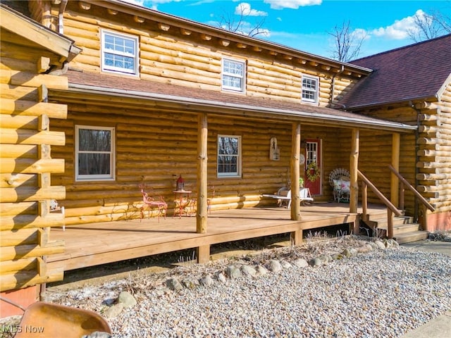 back of property featuring roof with shingles and log exterior