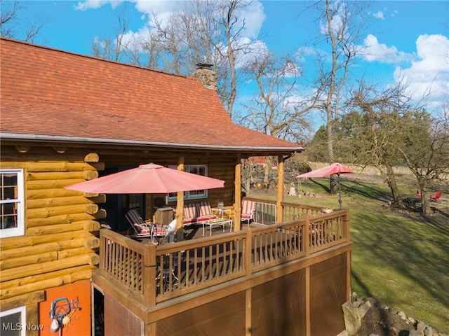 wooden terrace featuring a lawn