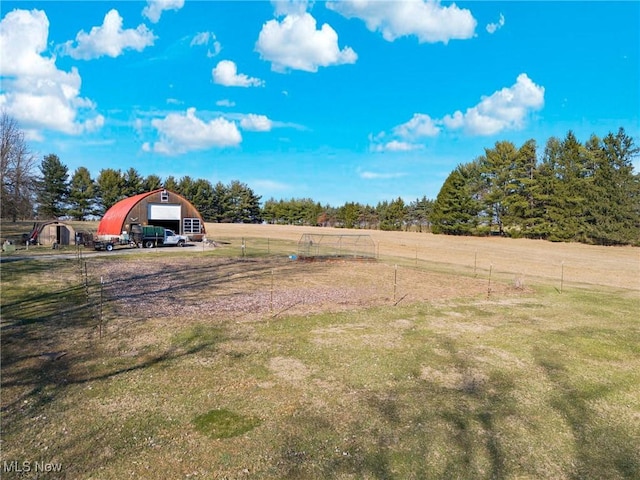 view of yard with an outbuilding, a rural view, and a detached garage