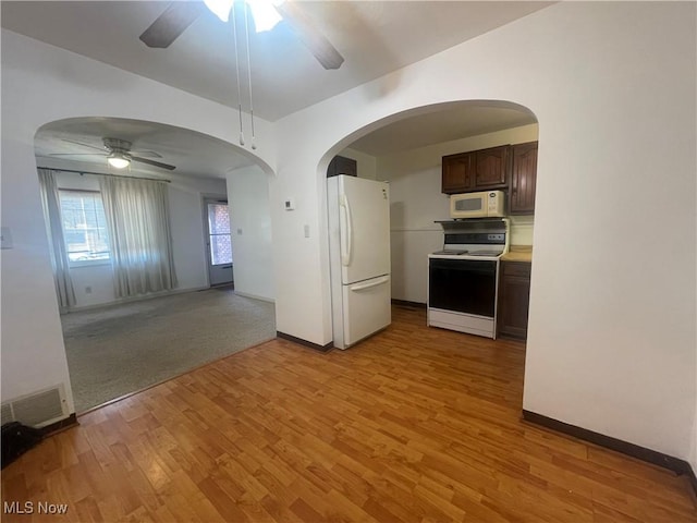 kitchen with light wood-type flooring, visible vents, white appliances, dark brown cabinetry, and ceiling fan