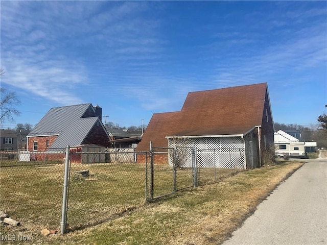 view of side of home with a lawn and fence