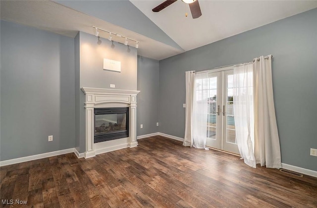 unfurnished living room with visible vents, baseboards, dark wood-type flooring, french doors, and a glass covered fireplace