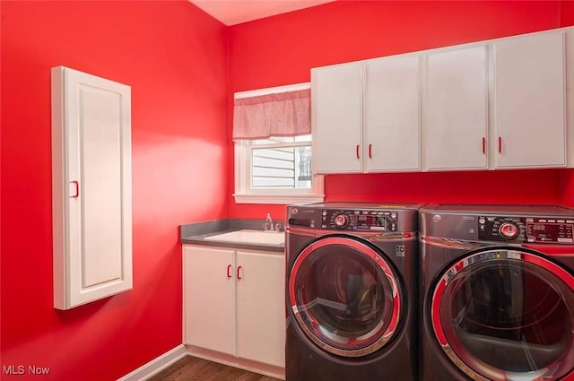 clothes washing area featuring baseboards, washer and dryer, wood finished floors, cabinet space, and a sink