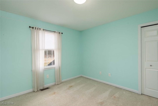 empty room with visible vents, baseboards, and carpet floors