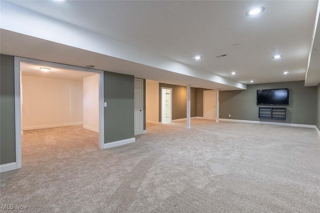 finished below grade area featuring visible vents, recessed lighting, light colored carpet, and baseboards