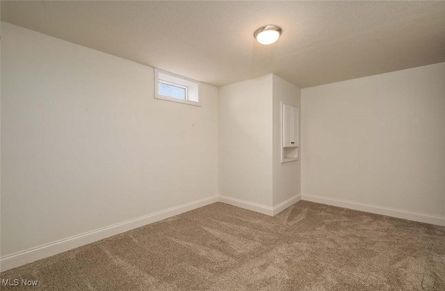 interior space featuring baseboards, carpet floors, and a textured ceiling