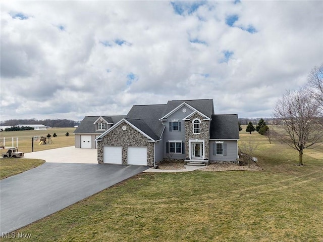 traditional-style house featuring stone siding, driveway, an attached garage, and a front lawn