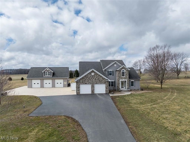 traditional-style home featuring stone siding, driveway, and a front lawn