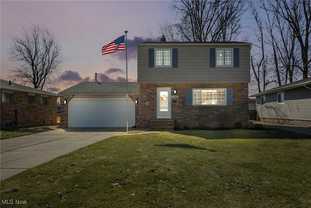 view of front of house with an attached garage, a lawn, brick siding, and driveway